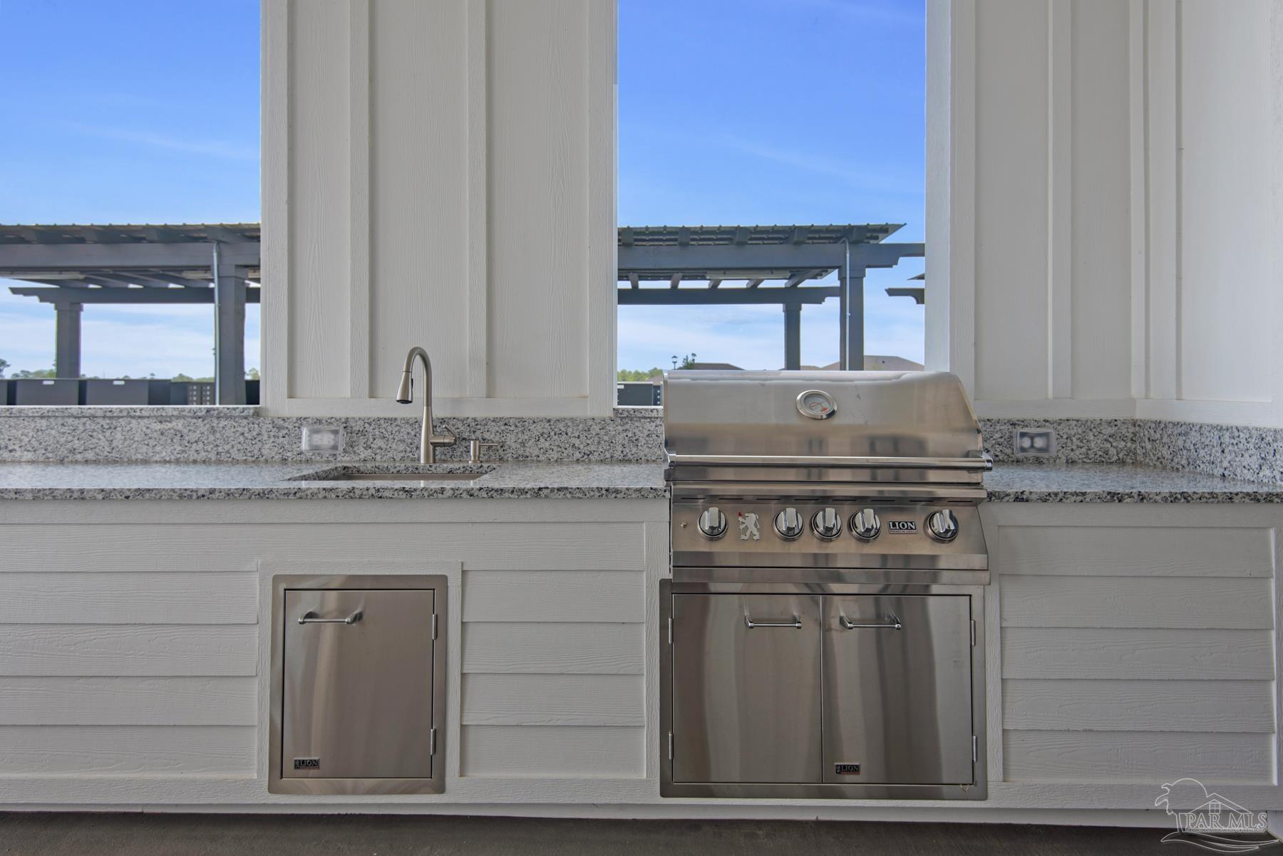 4739 Eider Road Pace, FL 32571 - Photo 28 of 30 a kitchen with granite countertop a sink stove and cabinets