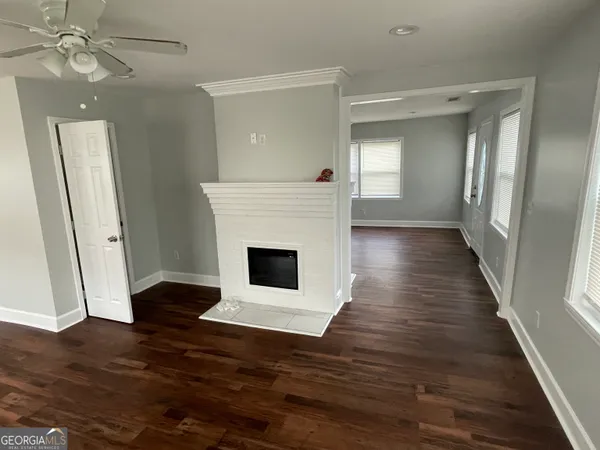 a view of a livingroom with wooden floor and a fireplace