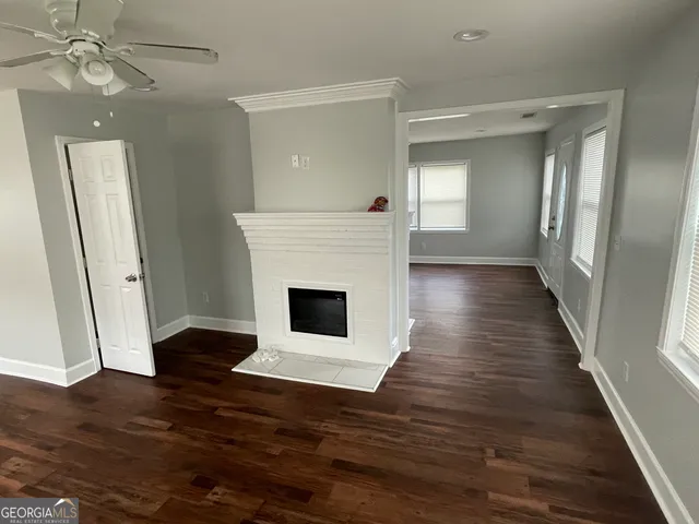a view of a livingroom with wooden floor and a fireplace
