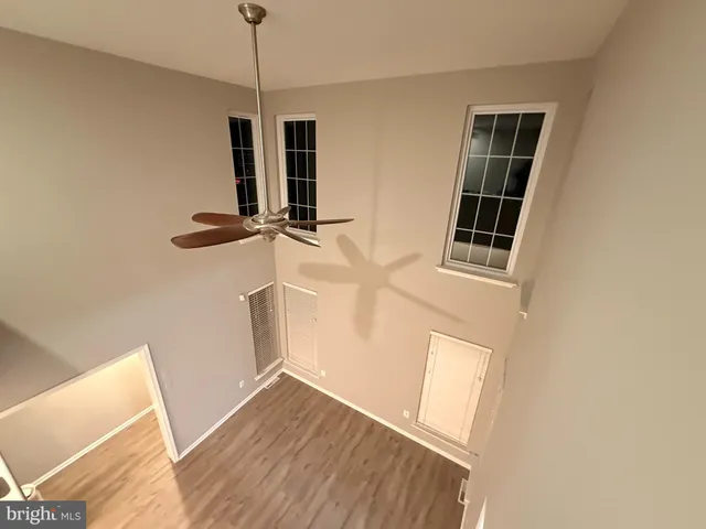 a view of empty room with wooden floor and window