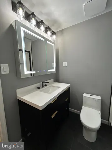 a bathroom with a toilet sink and mirror