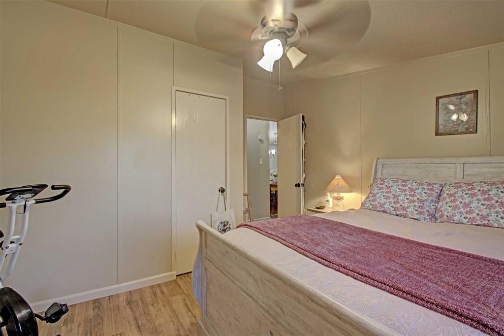 2004 Fall Creek Road Cleburne, TX 76033 - Photo 14 of 18 a spacious bedroom with a bed and a chandelier