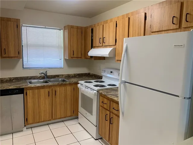 a kitchen with a refrigerator sink stove and cabinets