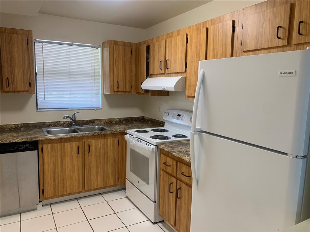 6001 Shaker Wood Circle, Unit 208 Tamarac, FL 33319 - Photo 2 of 13 a kitchen with a refrigerator sink stove and cabinets