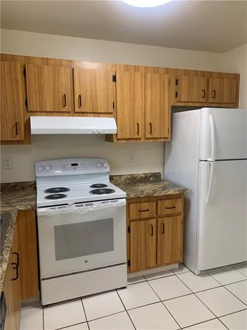 a kitchen with a stove top oven cabinets and a refrigerator