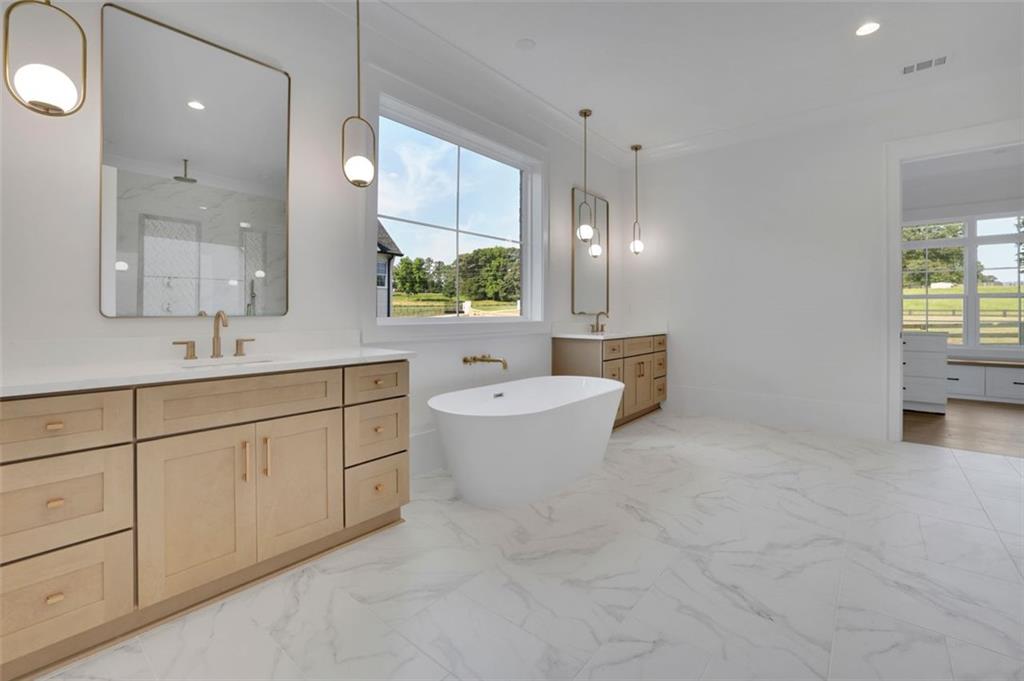 3903 Indian Shoals Road Southeast Bethlehem, GA 30620 - Photo 11 of 35 a bathroom with a double vanity sink a toilet a mirror and shower