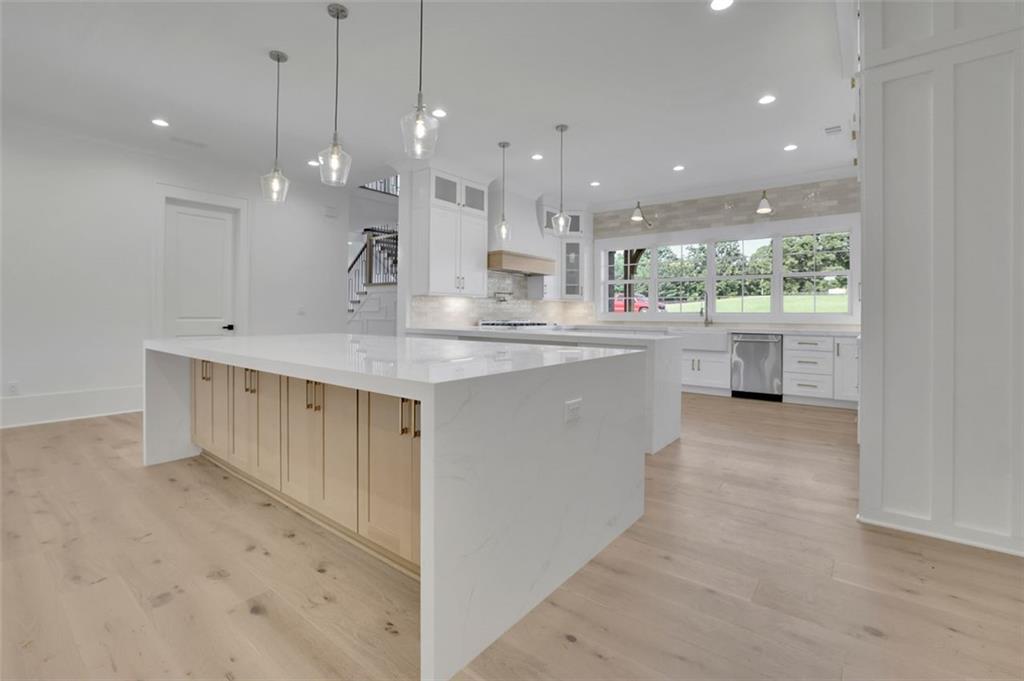 3903 Indian Shoals Road Southeast Bethlehem, GA 30620 - Photo 26 of 35 a large kitchen with kitchen island a large counter top a sink stainless steel appliances and cabinets
