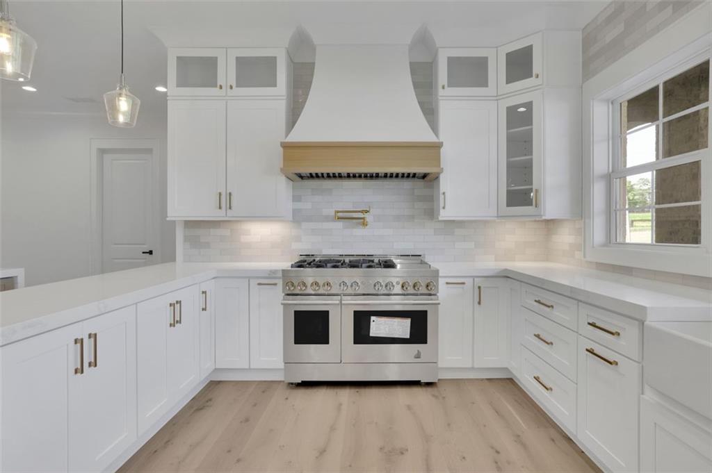 3903 Indian Shoals Road Southeast Bethlehem, GA 30620 - Photo 28 of 35 a kitchen with stainless steel appliances white cabinets and wooden floor