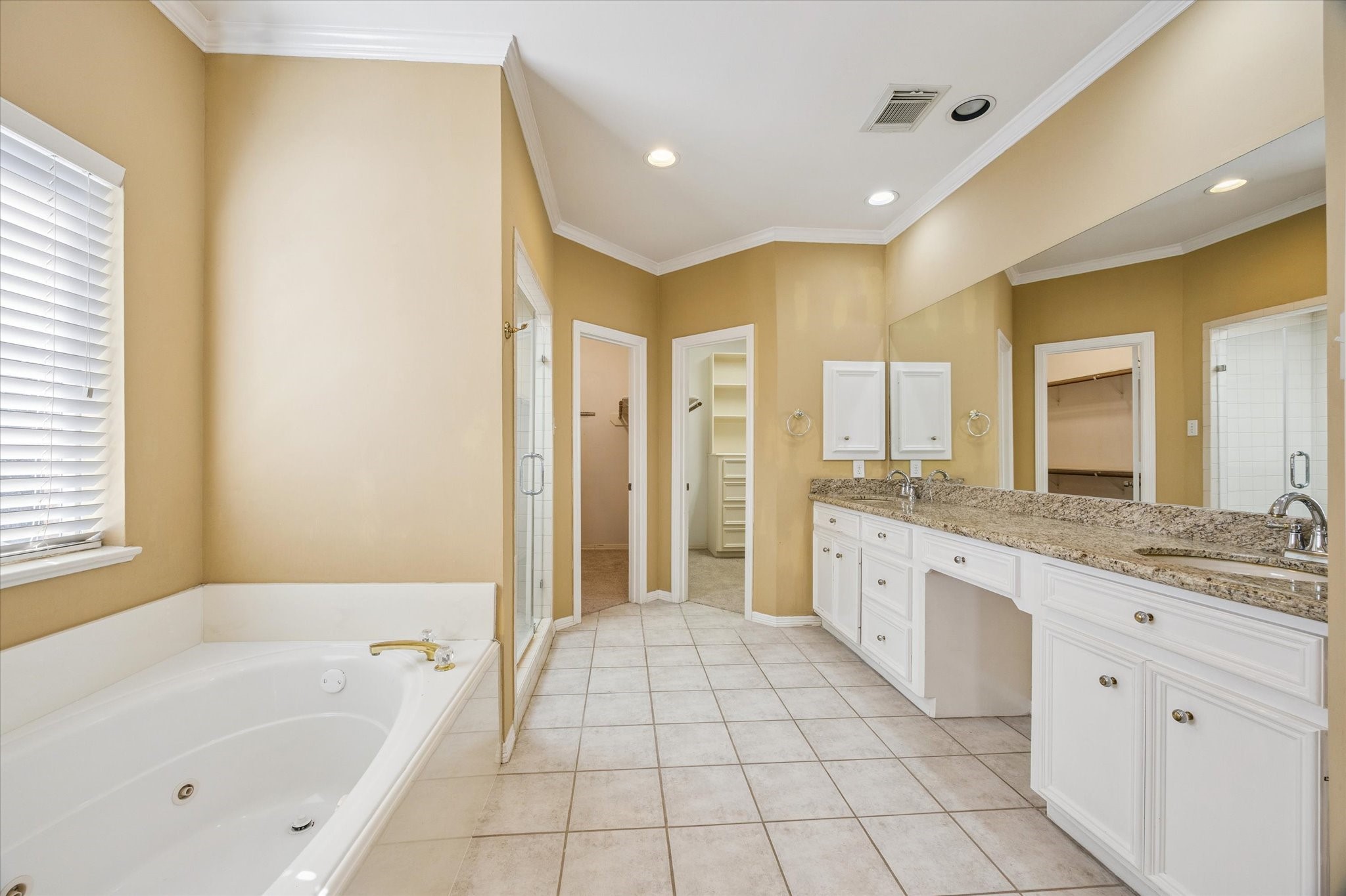 2410 Briar Ridge Drive Houston, TX 77057 - Photo 7 of 12 a spacious bathroom with a granite countertop sink a mirror a bathtub and next to a window