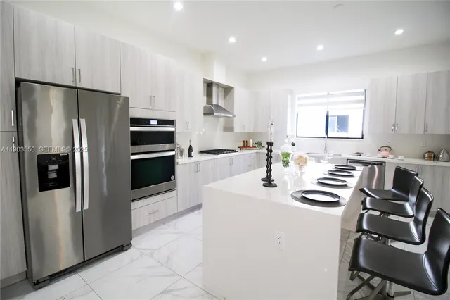 a kitchen with stainless steel appliances a refrigerator sink and stove