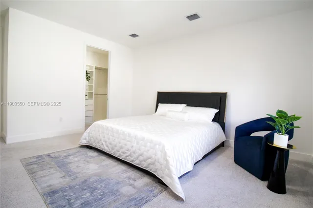 a bedroom with a bed and a potted plant