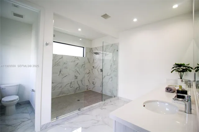 a bathroom with a double vanity sink a mirror and a bathtub