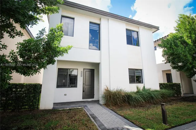 a white house with trees in front of it