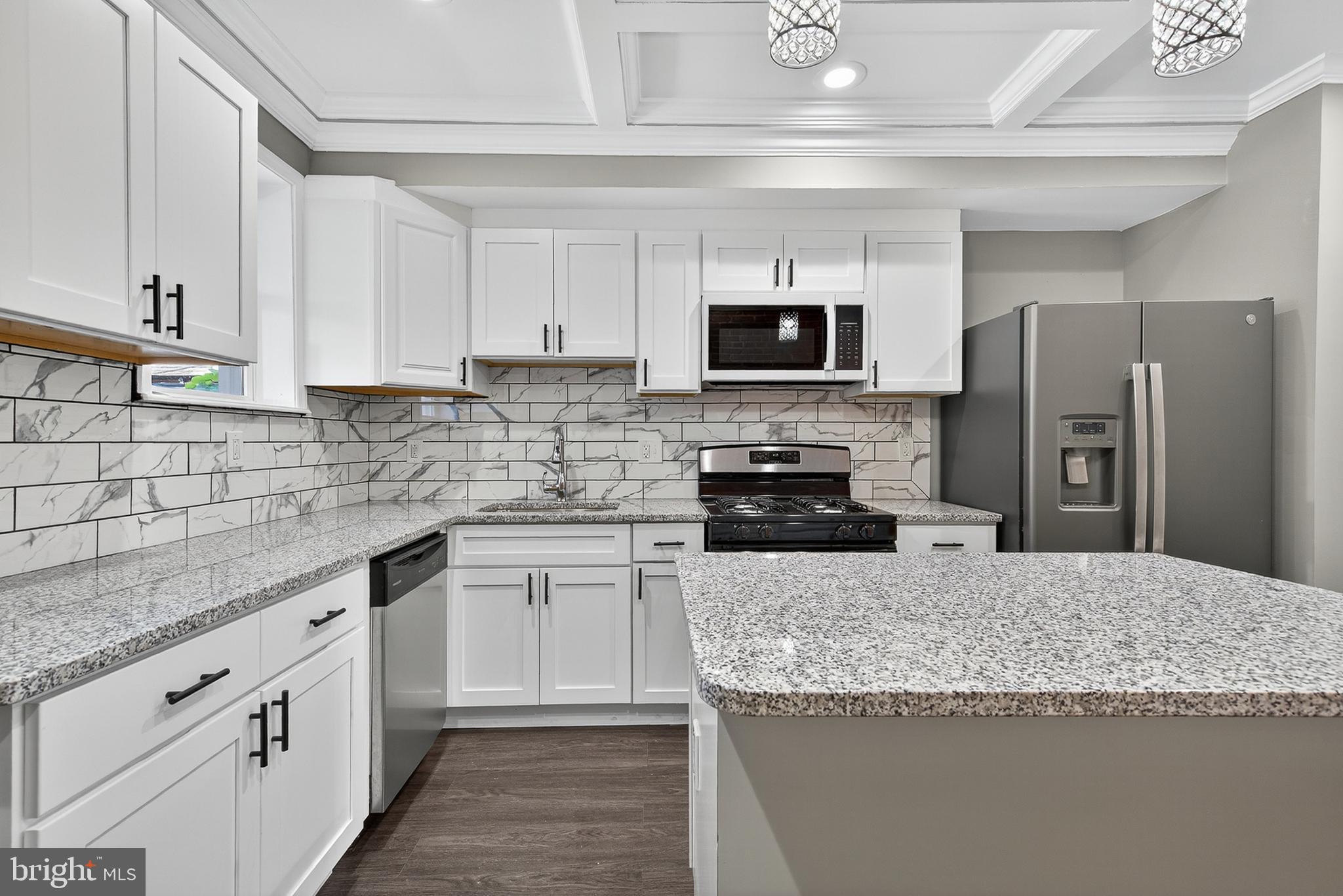 a kitchen with stainless steel appliances granite countertop a sink a stove top oven a refrigerator and dishwasher