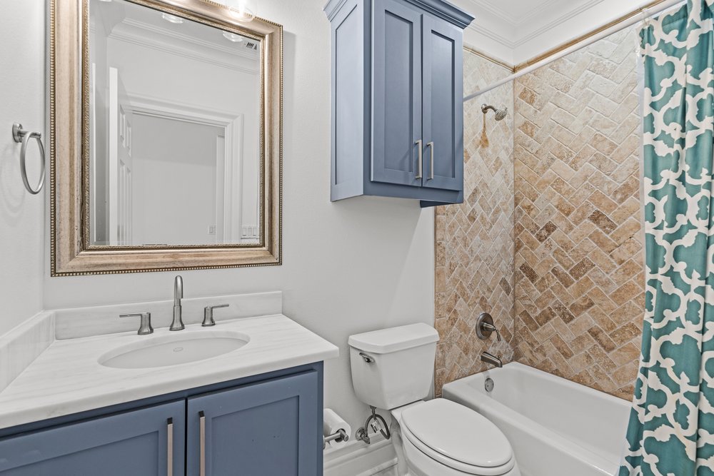 1609 Hartford Road, Unit A Austin, TX 78703 - Photo 37 of 39 Herringbone-patterned tiling and a clean, modern vanity elevate this pristine bathroom space.