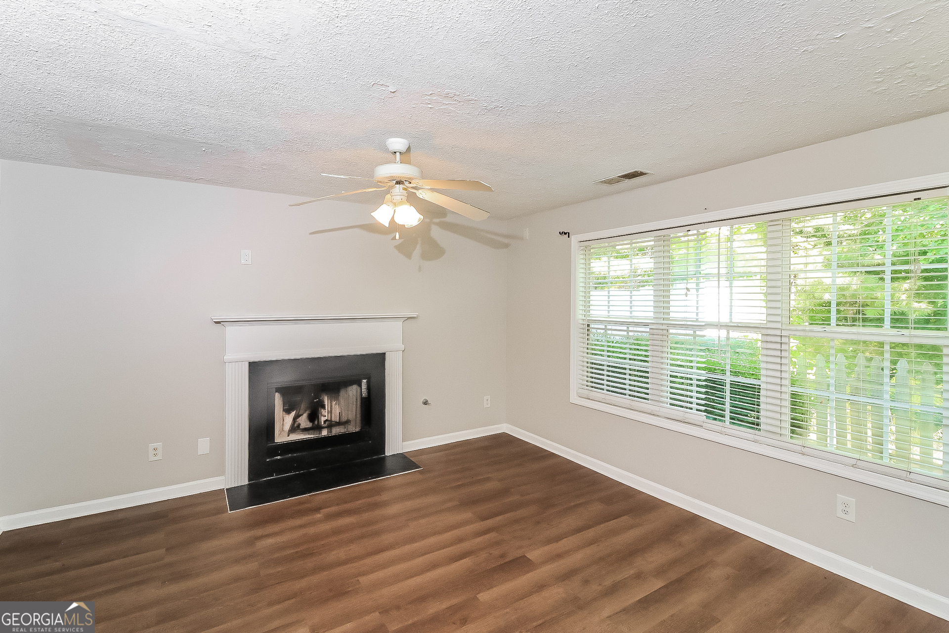 59 Greystone Ridge Hiram, GA 30141 - Photo 5 of 15 a view of an empty room with wooden floor fireplace and a window