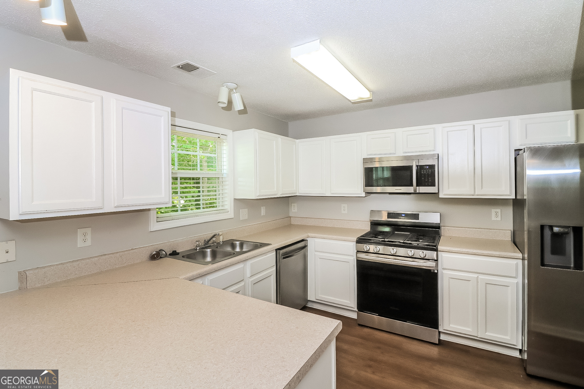 59 Greystone Ridge Hiram, GA 30141 - Photo 9 of 15 a kitchen with stainless steel appliances a stove a sink a microwave and wooden cabinets