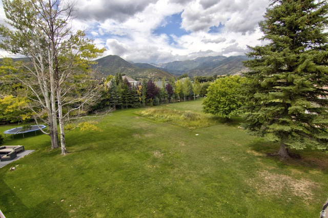 180 Farm Road Midway, UT 84049 - Photo 19 of 99 Expansive lawn area with mature trees and a mountain backdrop