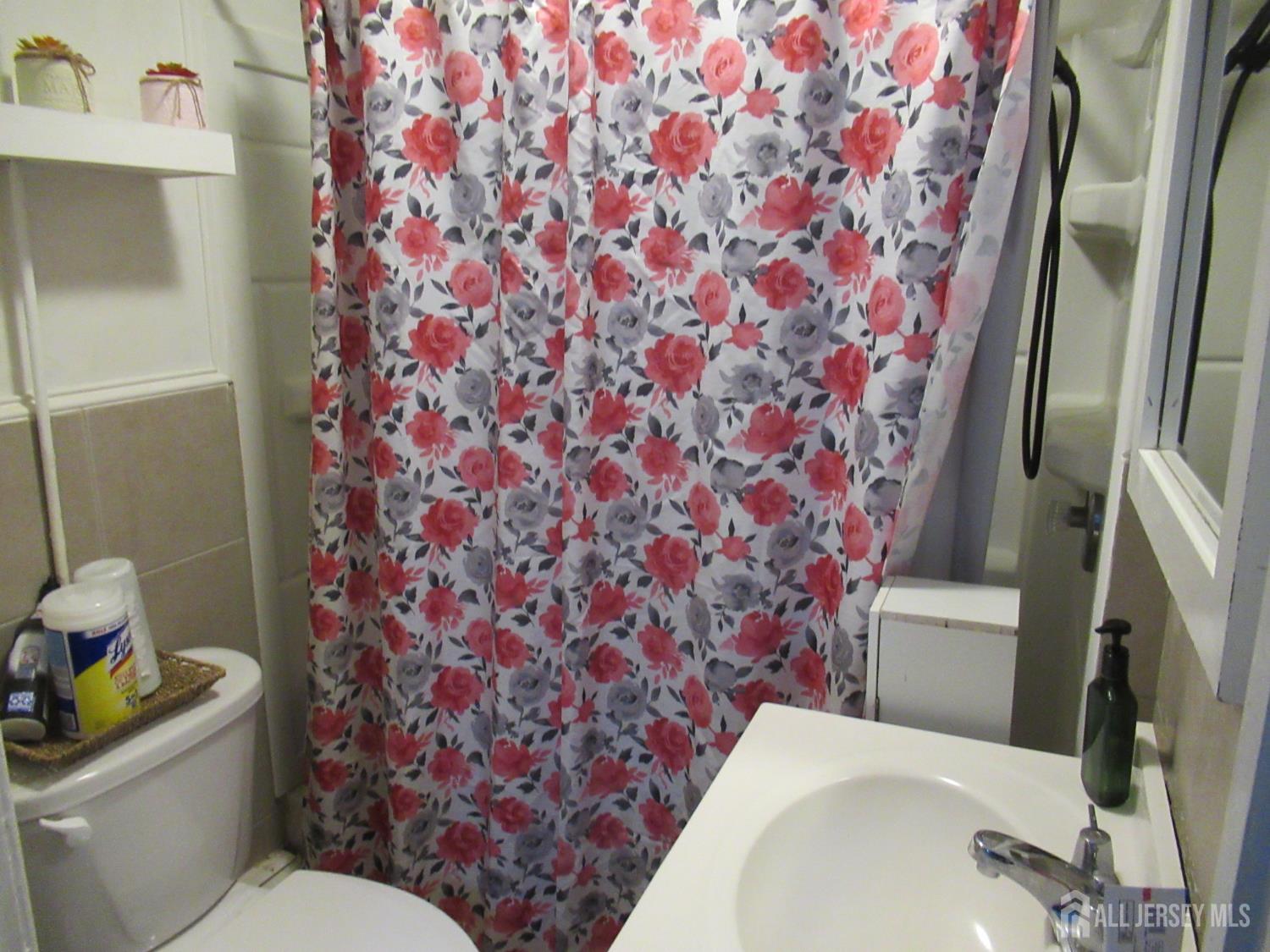 82 Pulaski Avenue Carteret, NJ 07008 - Photo 20 of 47 a white toilet sitting next to a shower curtain