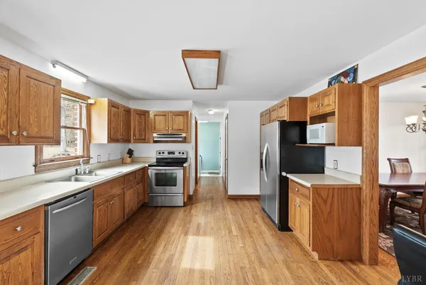 a kitchen with stainless steel appliances a stove top oven a sink dishwasher and a refrigerator