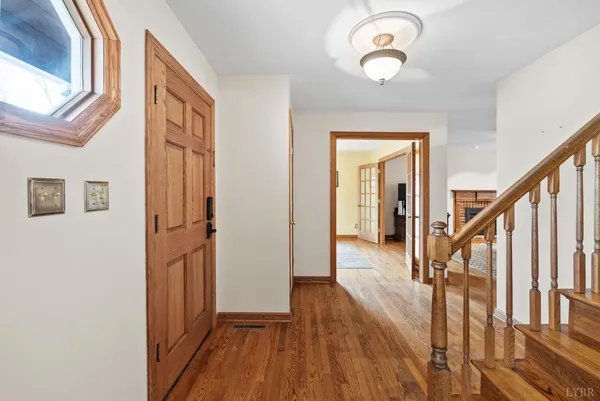 a view of a hallway with wooden floor and staircase