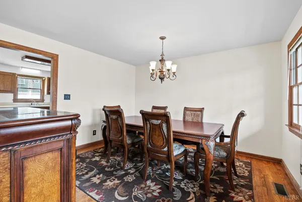 a view of a dining room with furniture a chandelier and wooden floor