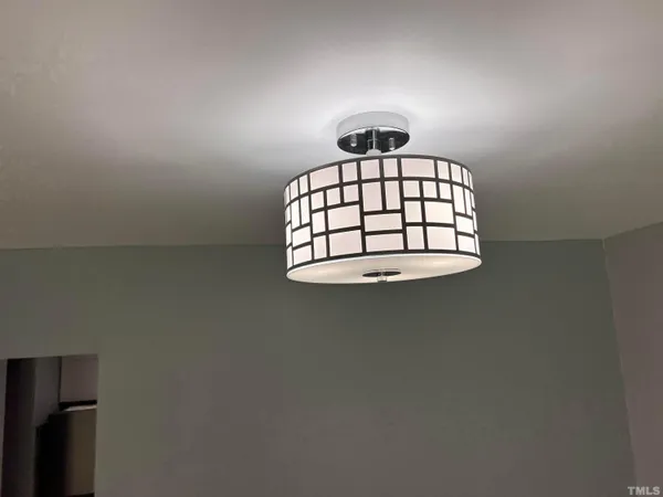a view of a hallway with wooden floor and chandelier