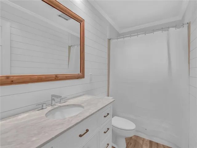 a bathroom with a granite countertop sink toilet and a mirror