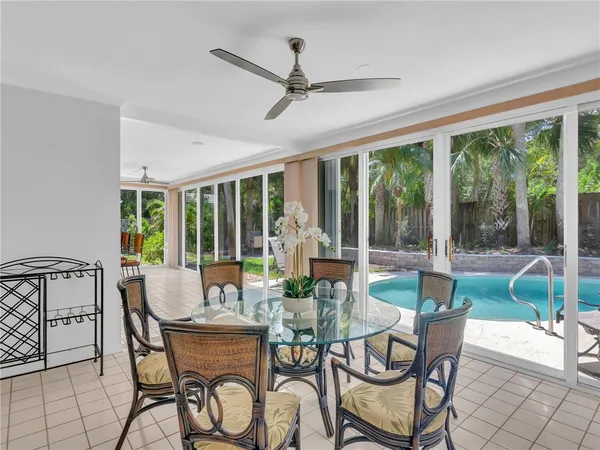 a dining room with furniture large windows and a chandelier
