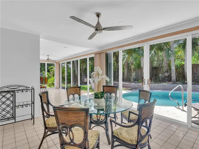 a dining room with furniture large windows and a chandelier
