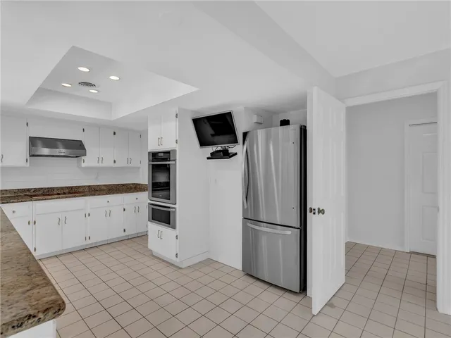 a kitchen with granite countertop a refrigerator and a sink