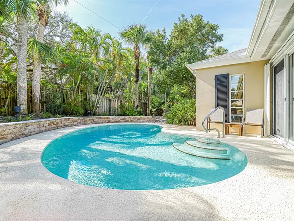 a view of a backyard with brick wall and potted plants