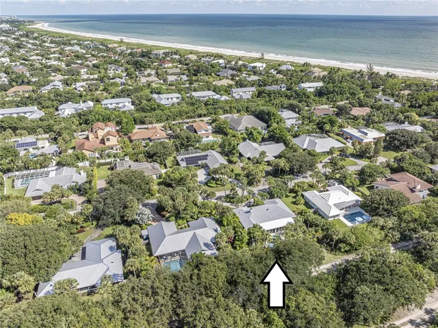 an aerial view of residential houses with outdoor space and trees