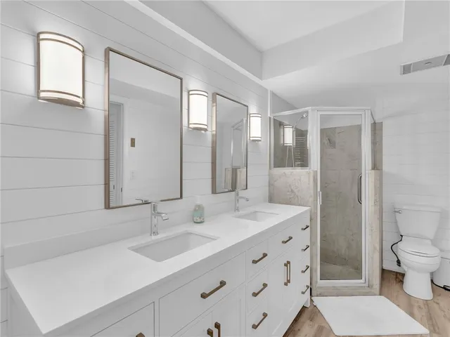 a bathroom with a double vanity sink mirror and toilet