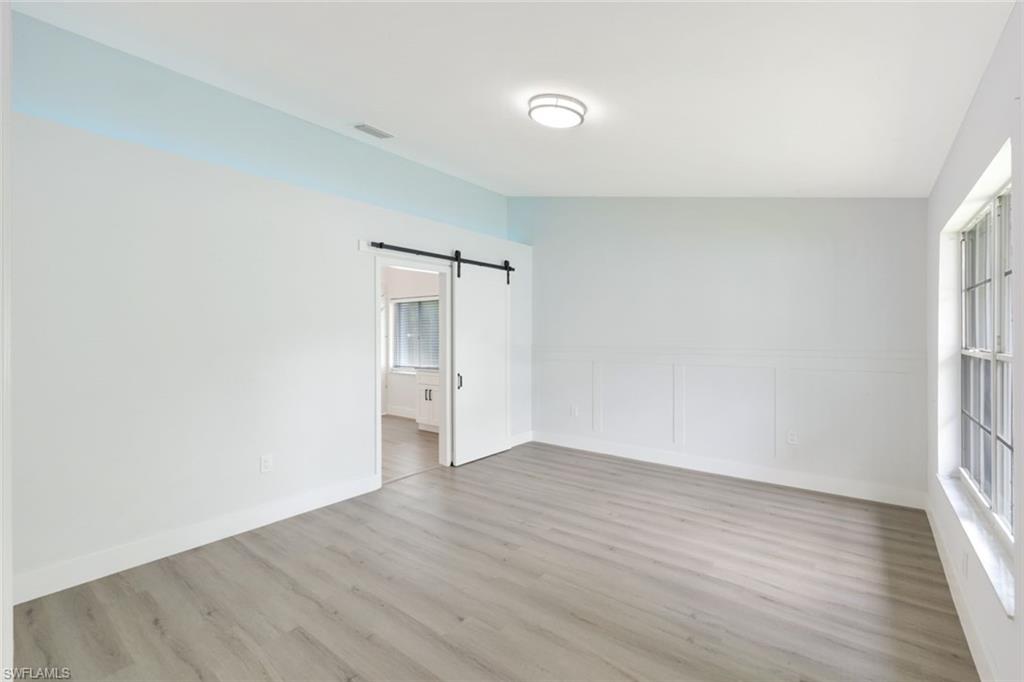 12800 Eagle Pointe Circle Fort Myers, FL 33913 - Photo 18 of 28 a view of an empty room with wooden floor and a window