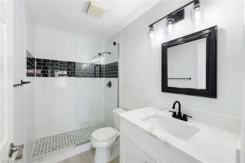 a bathroom with a sink toilet and mirror