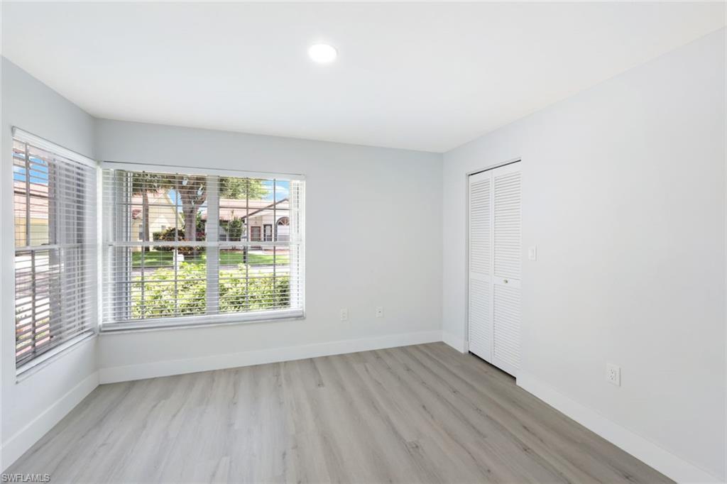 12800 Eagle Pointe Circle Fort Myers, FL 33913 - Photo 20 of 28 an empty room with wooden floor and windows