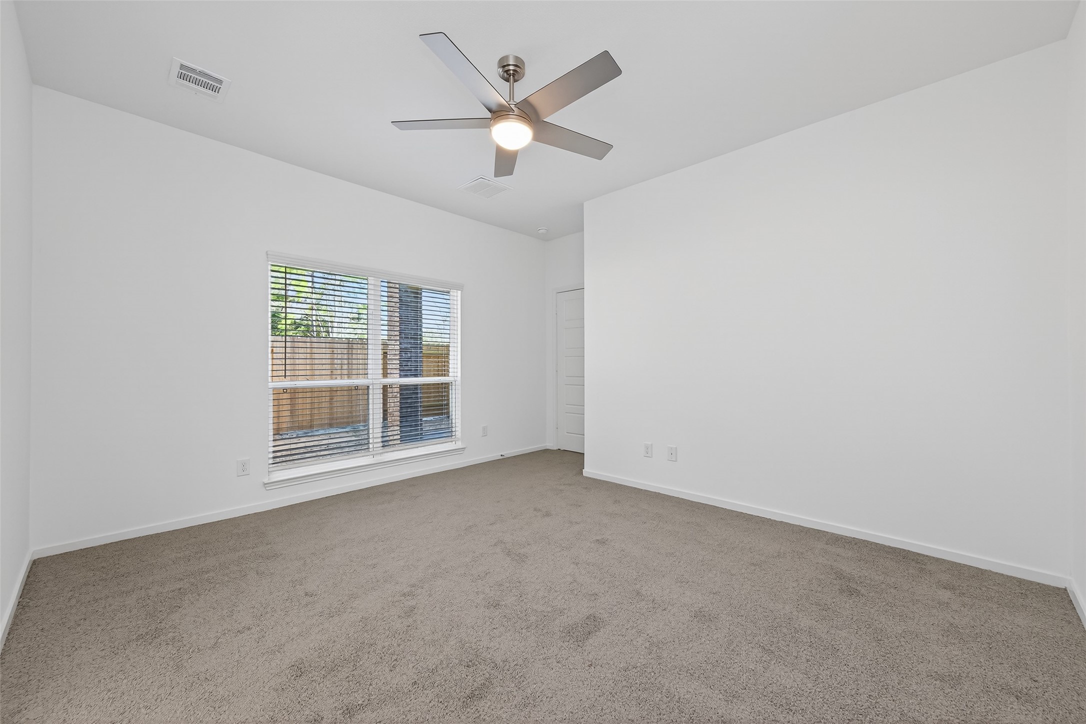 12375 Sunset Canyon Way Willis, TX 77318 - Photo 21 of 40 an empty room with a ceiling fan and a large window