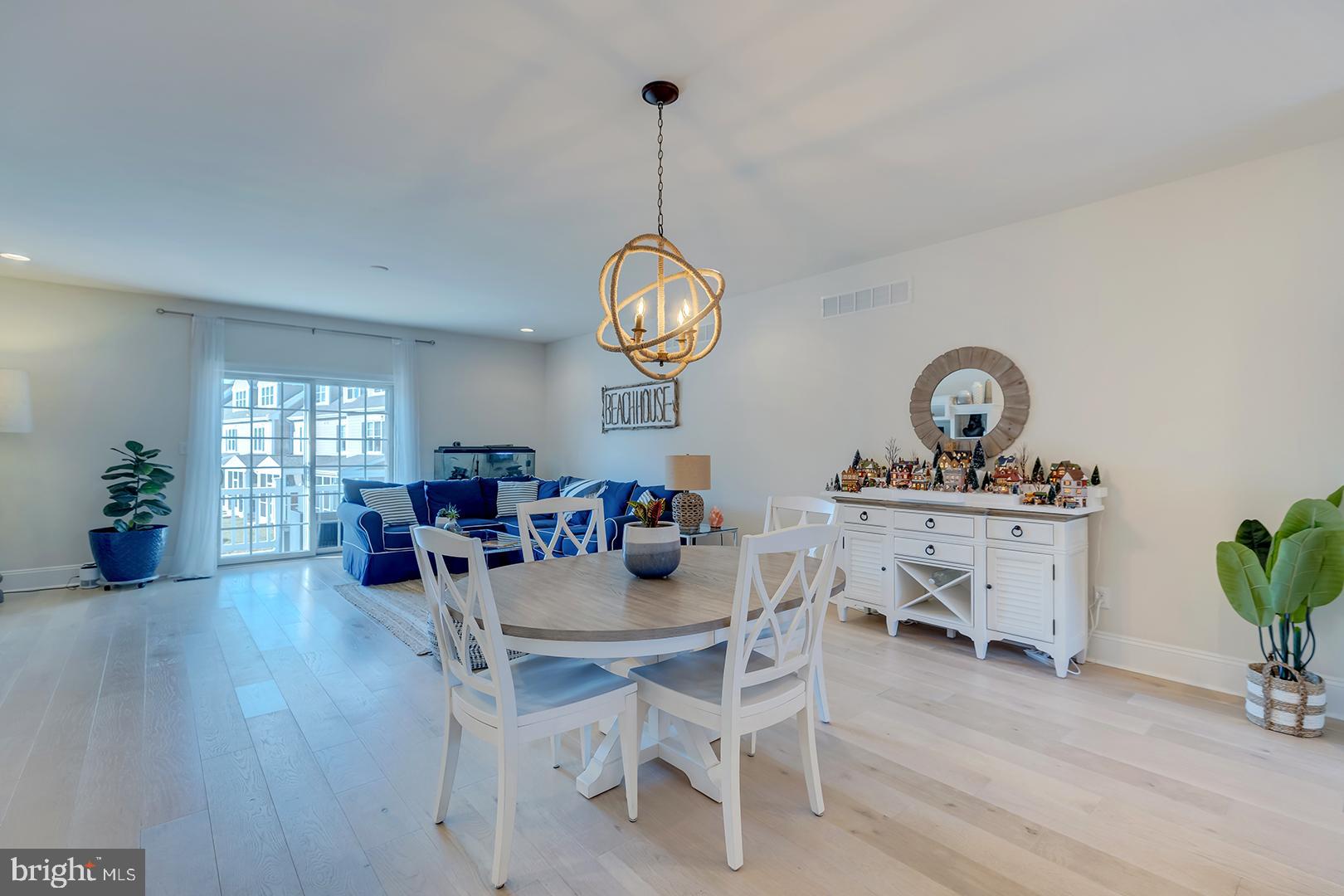 18799 Bethpage Drive, Unit 16E Lewes, DE 19958 - Photo 11 of 68 a view of a dining room and livingroom with furniture wooden floor a rug a potted plant and a chandelier