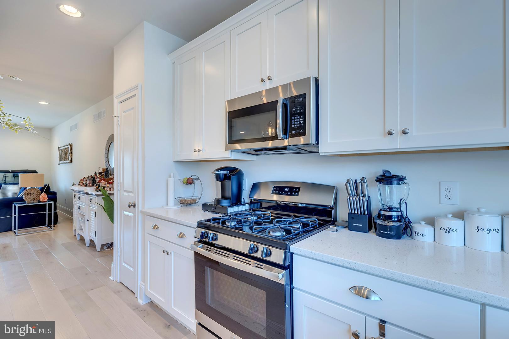 18799 Bethpage Drive, Unit 16E Lewes, DE 19958 - Photo 15 of 68 a kitchen with microwave a stove and cabinets