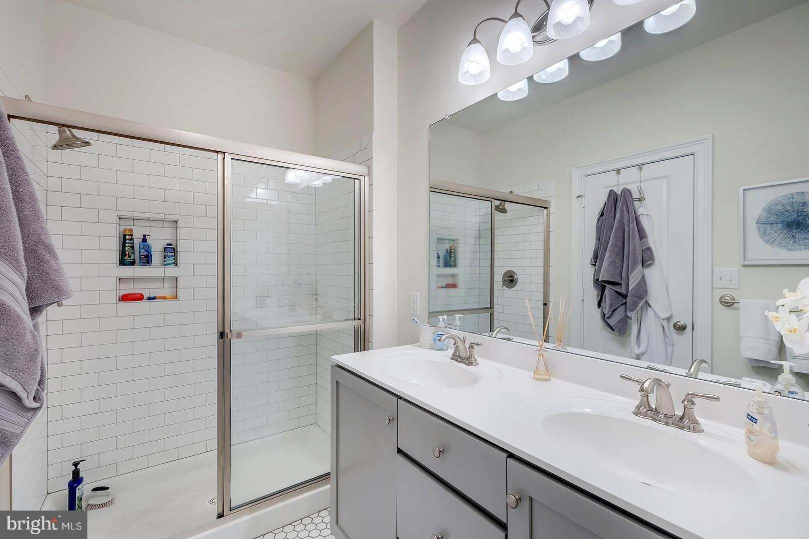 18799 Bethpage Drive, Unit 16E Lewes, DE 19958 - Photo 29 of 68 a bathroom with a double vanity sink mirror and shower