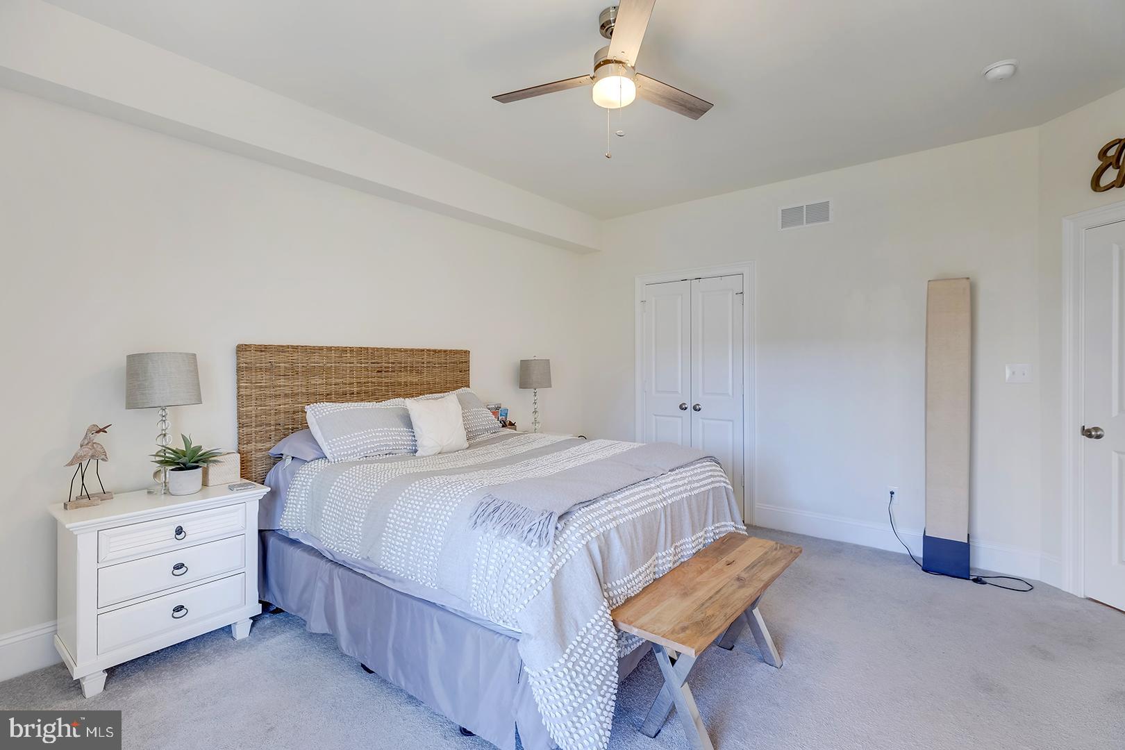 18799 Bethpage Drive, Unit 16E Lewes, DE 19958 - Photo 32 of 68 a bedroom with a bed and a chandelier