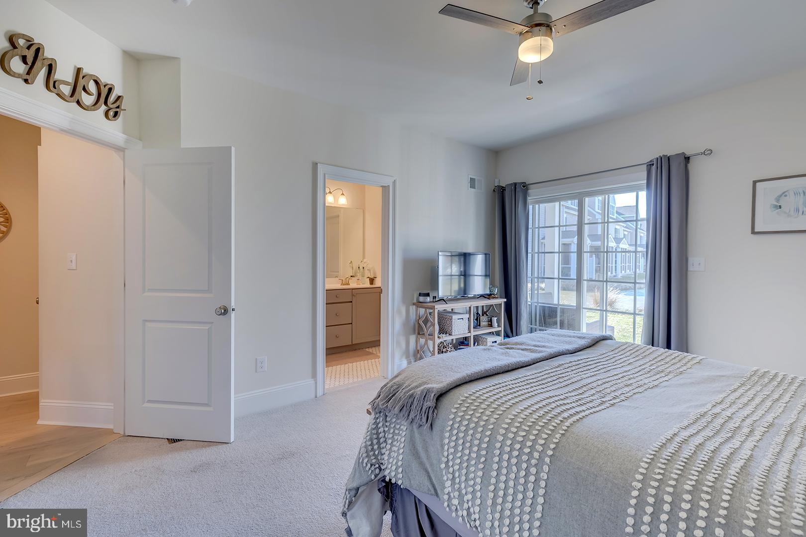 18799 Bethpage Drive, Unit 16E Lewes, DE 19958 - Photo 33 of 68 a bedroom with a bed and a chandelier