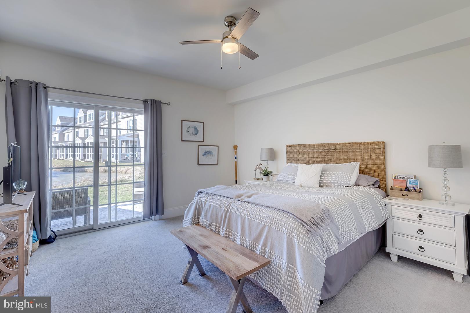 18799 Bethpage Drive, Unit 16E Lewes, DE 19958 - Photo 34 of 68 a bedroom with a bed and a chandelier