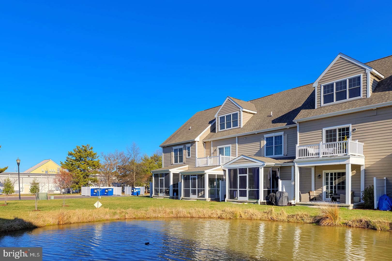 18799 Bethpage Drive, Unit 16E Lewes, DE 19958 - Photo 46 of 68 a front view of a house with swimming pool and lake view