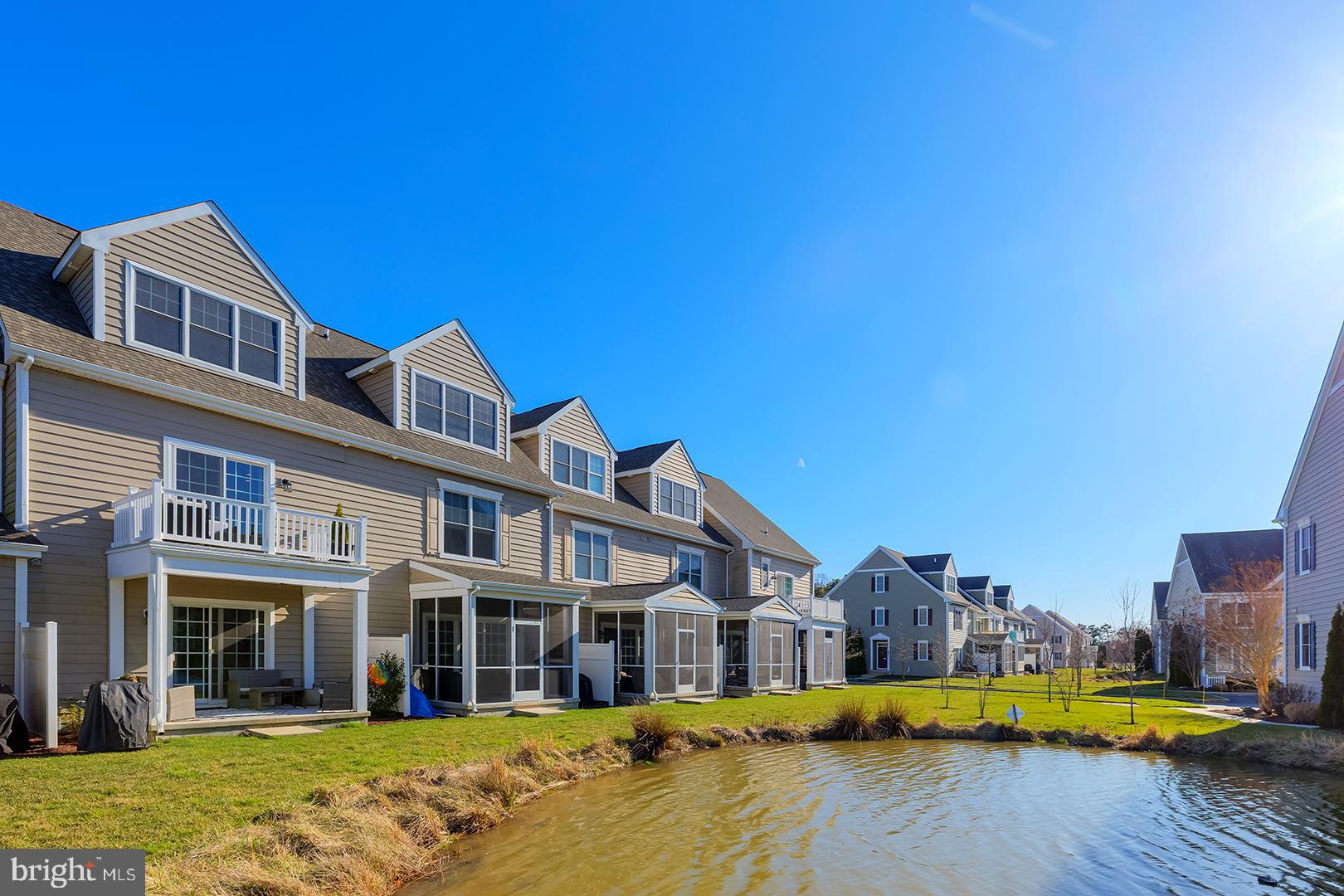 18799 Bethpage Drive, Unit 16E Lewes, DE 19958 - Photo 47 of 68 a view of a swimming pool with a lawn chairs under an umbrella