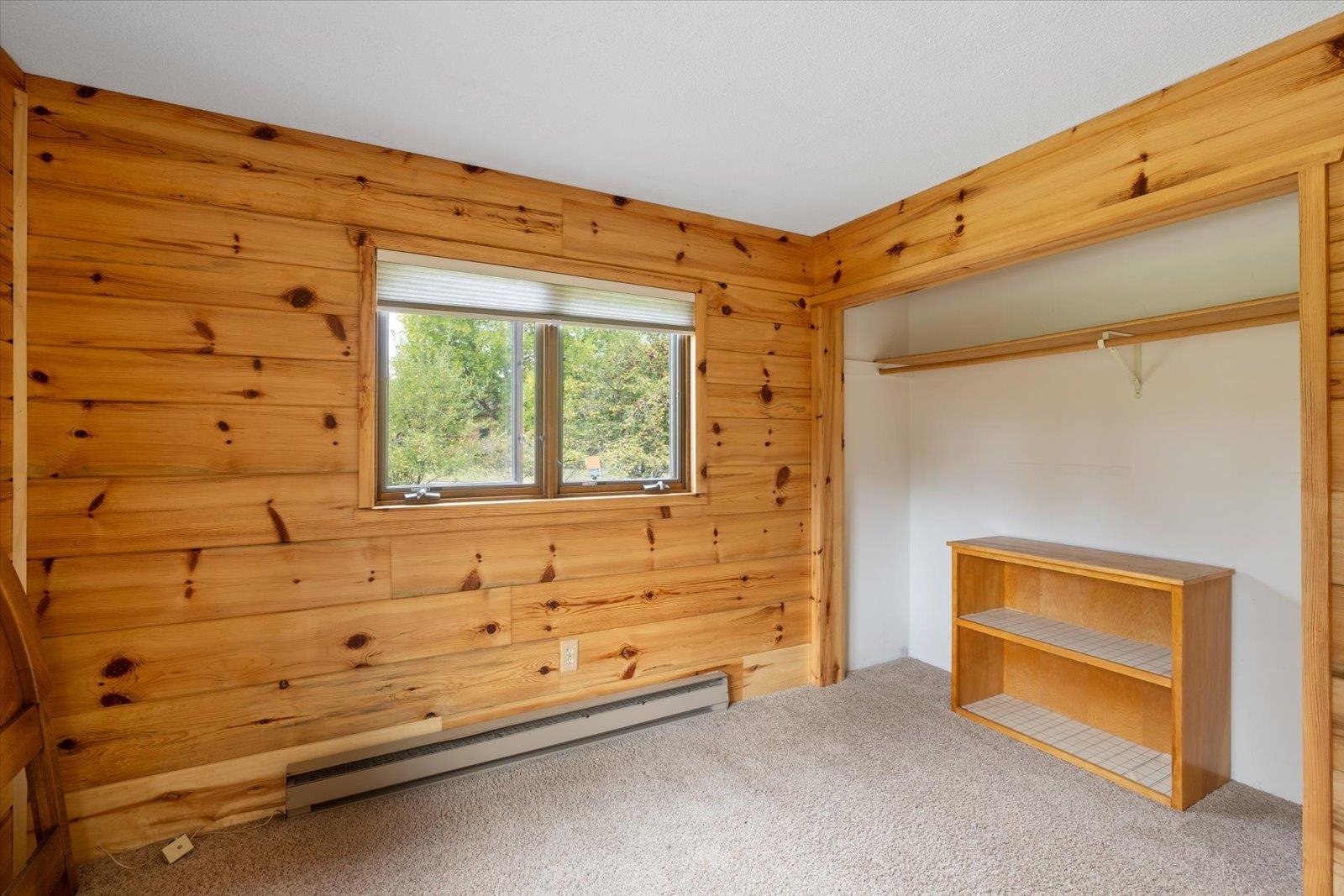 236 East Ahola Road Ely, MN 55731 - Photo 13 of 27 Unfurnished bedroom with a baseboard heating unit, carpet flooring, a closet, and wooden walls