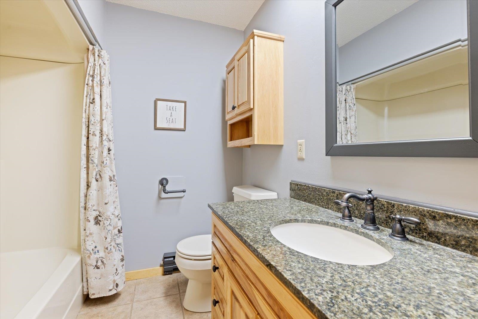 236 East Ahola Road Ely, MN 55731 - Photo 17 of 27 Bathroom featuring light tile patterned flooring, vanity, and shower / bath combo with shower curtain