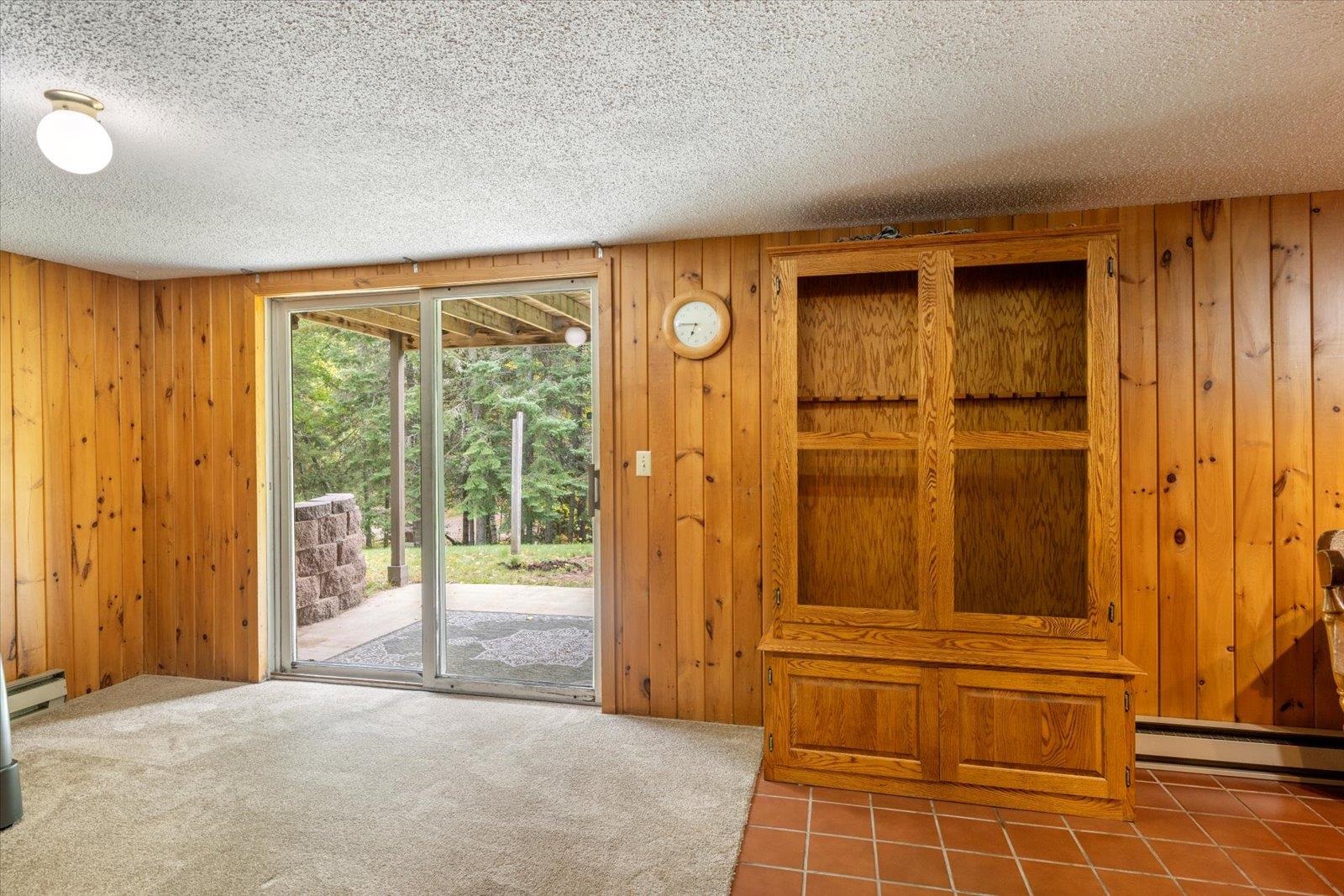 236 East Ahola Road Ely, MN 55731 - Photo 2 of 27 Entryway featuring wood walls, a textured ceiling, carpet flooring, and baseboard heating