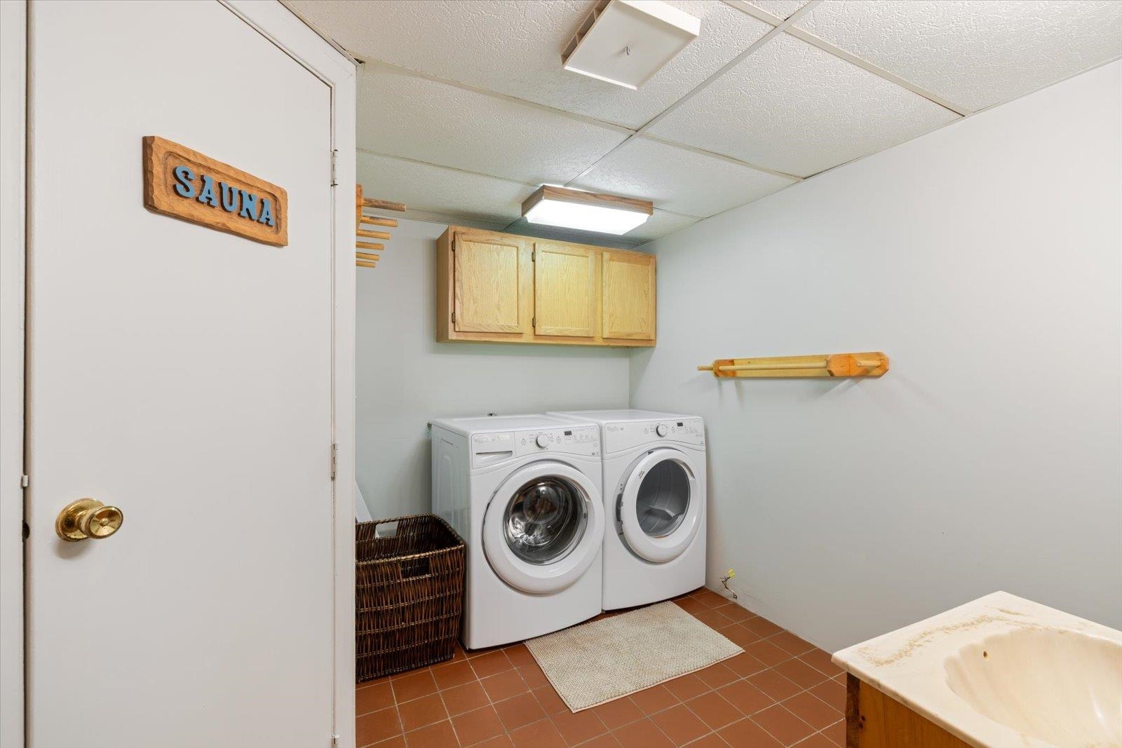 236 East Ahola Road Ely, MN 55731 - Photo 21 of 27 Laundry room featuring cabinet space, dark tile patterned flooring, and washing machine and clothes dryer